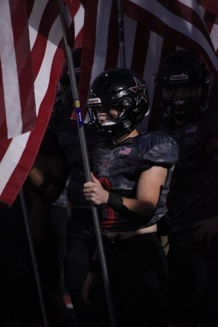 Coppell senior wide receiver Zack Darkoch stands with the American flag on Heroes Night at Buddy Echols Field on Oct. 21. Darkoch grows in confidence in his wide receiver position as a senior.