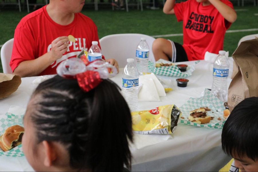 Coppell students eat food catered by Dickey’s Barbecue Pit in the Coppell High School Fieldhouse on Oct. 21. The Coppell ISD annual community tailgate took place prior to Coppell’s game against Hebron at Buddy Echols Field.