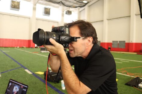 Concept 7 owner Frank Marott takes an individual portrait of Coppell High School senior lacrosse player Tom O’Hearn at the Coppell High School field house on Saturday. Marott has been a photographer for 25 years and serves the Coppell community.