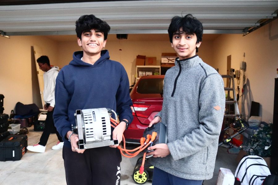 Coppell High School sophomores Aayush Shah and Shreyes Ram hold a solar car engine on Wednesday. Shah is the President of the CHS Solar Racing Team, in which he explores alternative energy sources. 