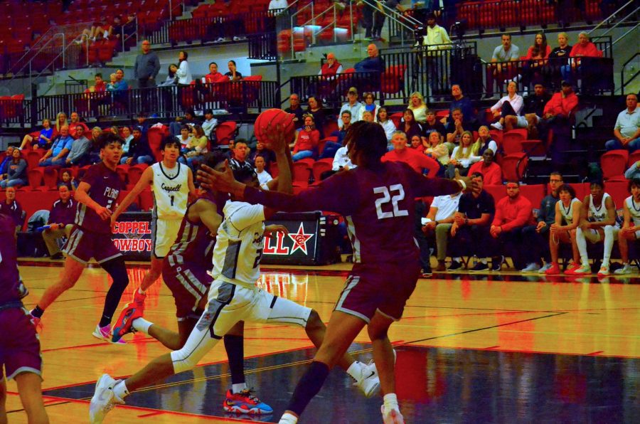 Coppell sophomore point guard James Faison hits a Eurostep on the Plano defense and kicks it out to junior guard Gabe Pehl for a 3-point attempt on Friday at CHS Arena. Plano defeated Coppell, 58-40.