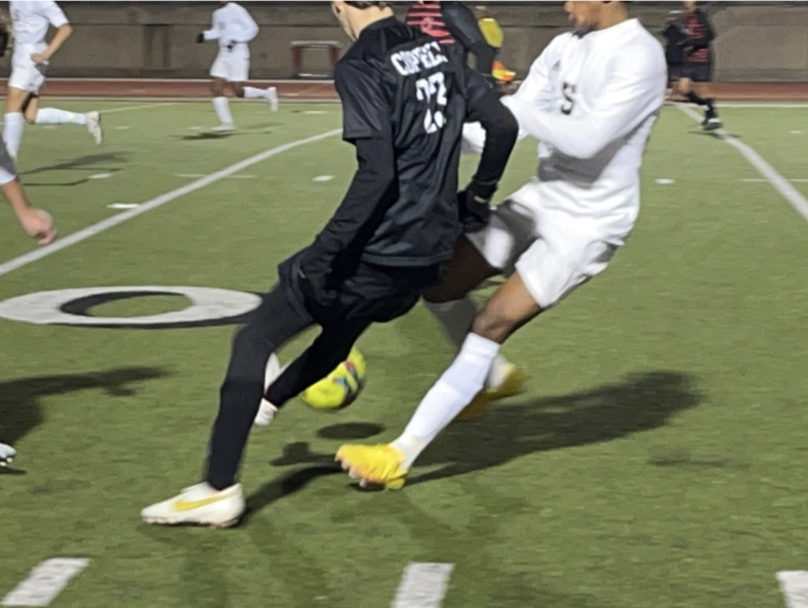 Coppell senior forward Alfred Fairchild turns against a Plano East defender at Buddy Echols Field on Friday. Coppell and Plano East tied, 1-1. Photo by Wendy Le.