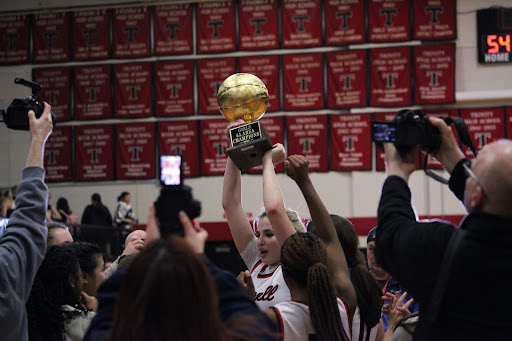 Coppell senior forward Jules LaMendola holds the Class 6A Region I area championship trophy at Euless Trinity on Thursday. Coppell defeated Highland Park to become 6A Area Champions, 54-41.