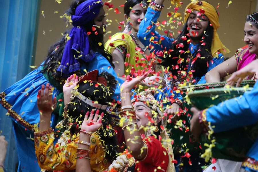 Dancers throw red and yellow flower petals at other dancers depicting Hindu god Krishna and a Gopi inside the Radha Govind Dham temple on Sunday. Radha Govind Dham celebrates Braj-style Holi, the festival of colors, with flowers, food and dances.