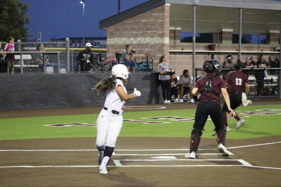 Coppell sophomore Nevaeh Carter scores against Lewisville at the Coppell ISD Baseball/Softball Complex on Tuesday. The Cowgirls lost, 13-3, to the Farmers.