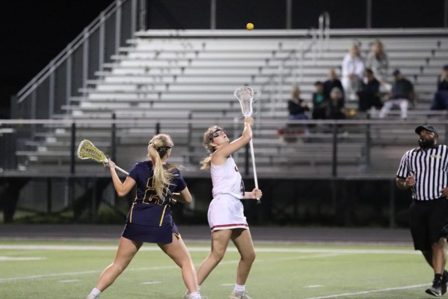 Coppell junior midfielder Kate Nelson throws the ball in the air after a face off against Highland Park on Tuesday night. Highland Park defeated Coppell, 15-10.