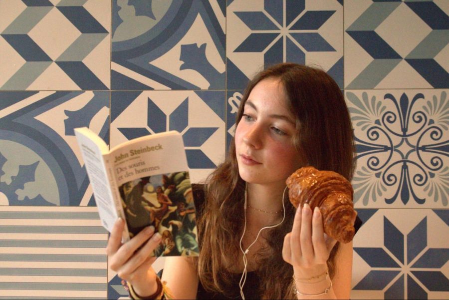 Coppell High School sophomore Léonor Danober enjoys a croissant while reading Des souris et des hommes, the French translation of novel Of Mice and Men by John Steinbeck. Danober recently migrated to Coppell from Antony, France in November and has been adjusting to a new environment after living in a different country for most of her life. 