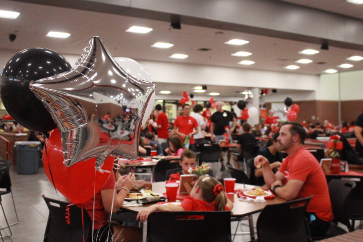 Friends and family chat and enjoy dinner catered by Bistecca at the Lariette Spaghetti Dinner in the Coppell High School  Large Commons on Friday. The Lariette Spaghetti Dinner is an annual fundraiser and community event celebrating the beginning of the football season.