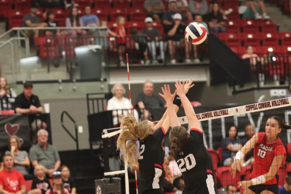 Coppell senior opposite hitter Mira Klem and sophomore middle blocker Kaitlin Keith block a spike from  Flower Mound Marcus senior right side Rachel Sturton. The Cowgirls defeated the Marauders, 22-25, 25-17, 25-18, 18-25, 15-13.
