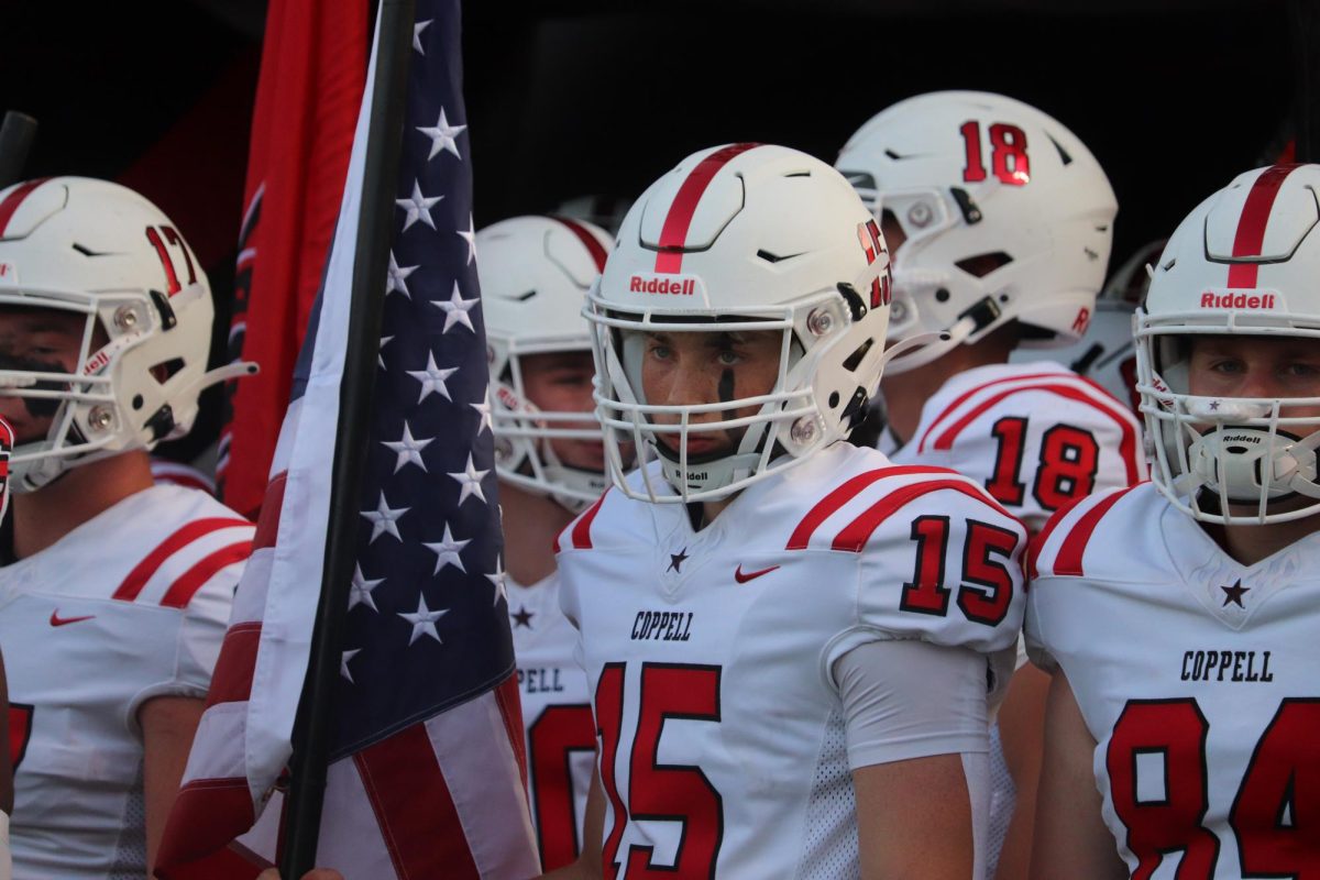 Coppell senior defensive back Luke Hurt holds the American flag with senior tight end Tuck Walker prior to the game against South Grand Prairie at Gopher-Warrior Bowl on Sep. 1. Coppell defeated the Warriors, 44-34.