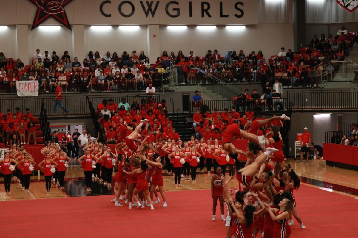 Coppell Cheer performs stunts to raise school spirit at the pep rally on Sept. 29 at the Coppell High School arena. The red out pep rally during first period had students come out to cheer in support of the CHS varsity football team for their game against Lewisville.
