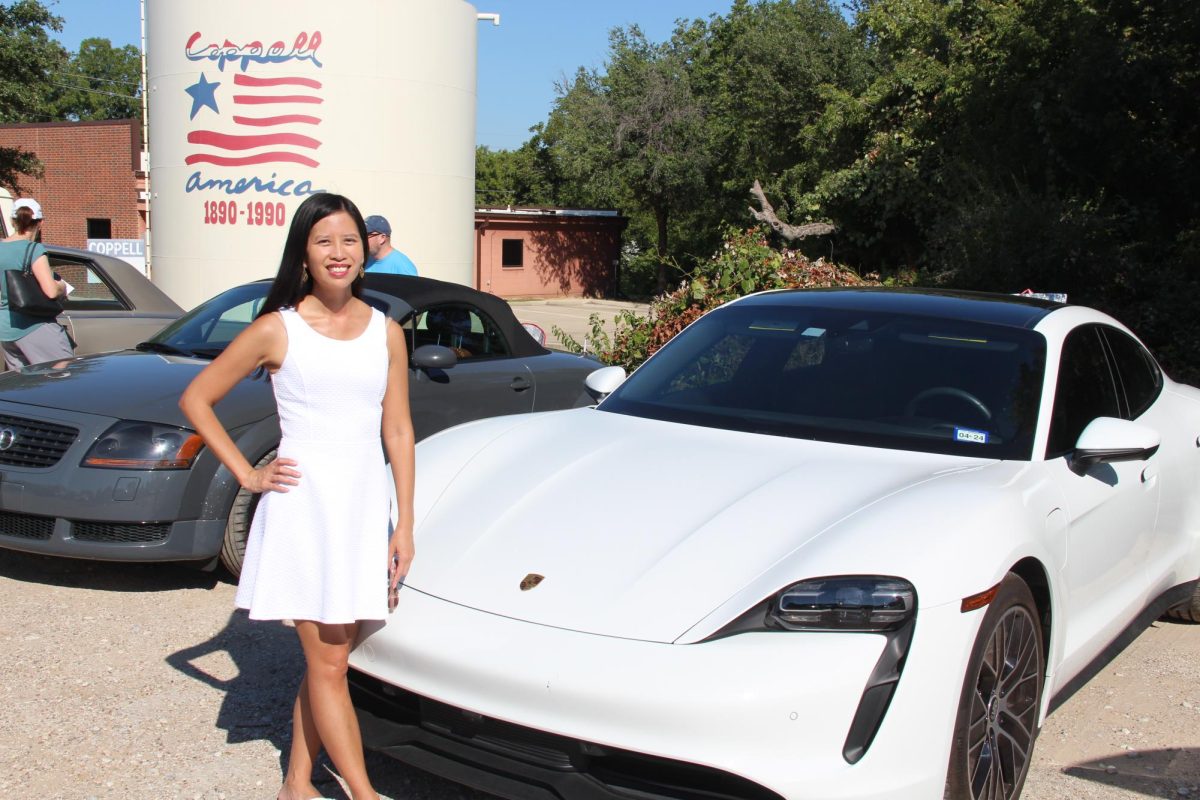 Julie Waters, one of the organizers of the car show, poses with her 2021 Taycan Porsche. Old Town Coppell hosted its annual car show on Sept. 30, where members of the community put their cars on display for attendees to see. 