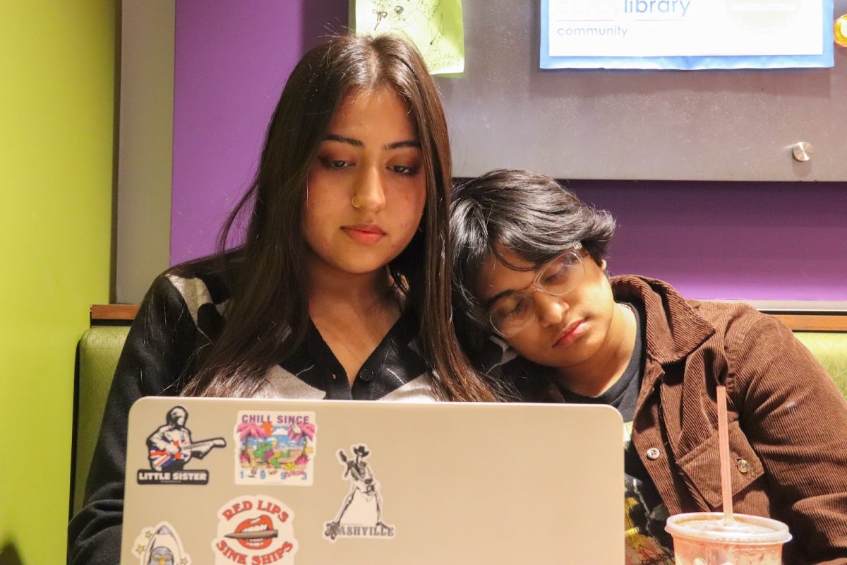 The Sidekick staff writer Neha Nathwani works on her laptop as Coppell High School senior Sirini Karundasa sleeps on her shoulder. Nathwani is grateful for the sanctuary that the Cozby Library and Community Commons provides. 
