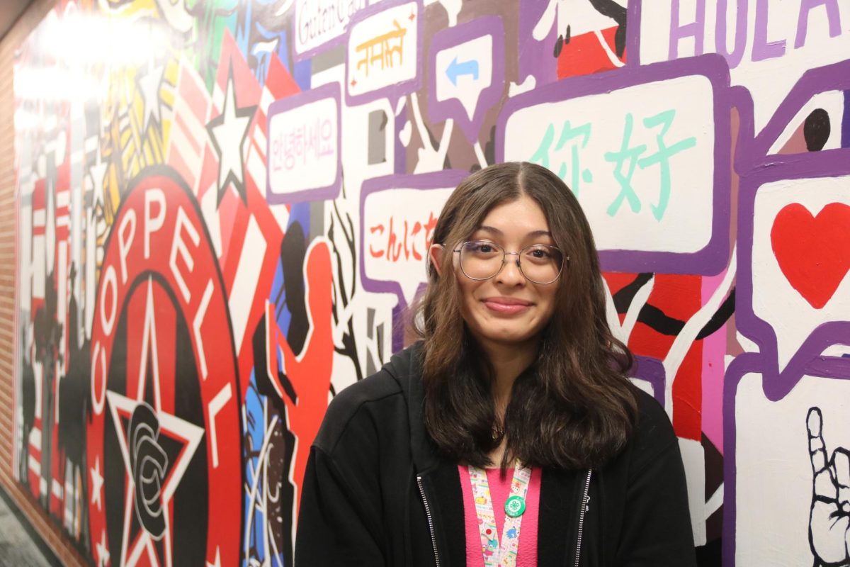 Coppell High School sophomore Gabriella Pardo stands near the CHS mural, decorated with hello in a multitude of languages. Over the summer, Pardo hosted Yuzuka Sugiura, a foreign exchange student from Japan, which provided her with new perspectives and experiences. 