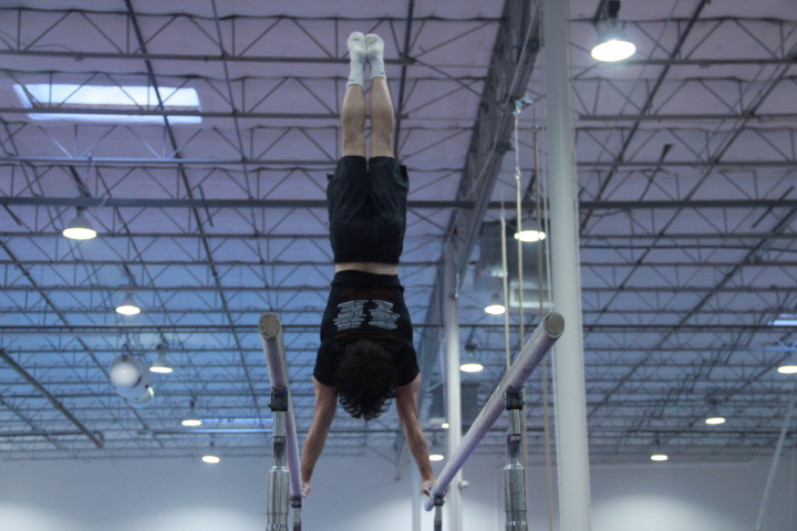 Coppell senior Davide Comparin practices his bar routine on Dec. 4. Comparin is a Level 10 gymnast at Texas Dreams Gymnastics in Coppell, previously placing first at nationals, practicing daily from 3-7 p.m. 
