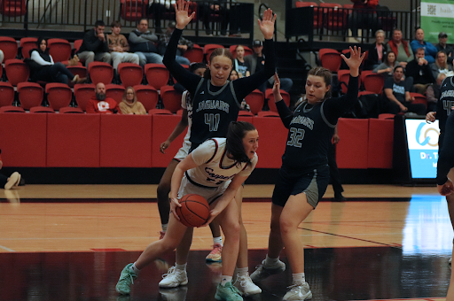 Coppell senior guard Ella Spiller looks to pass while being guarded by Flower Mound senior Kaitlyn Edmondson and junior guard Maya Bujak at CHS Arena on Friday. The Cowgirls host Hebron on Tuesday at 6:15 p.m. for Senior Night.