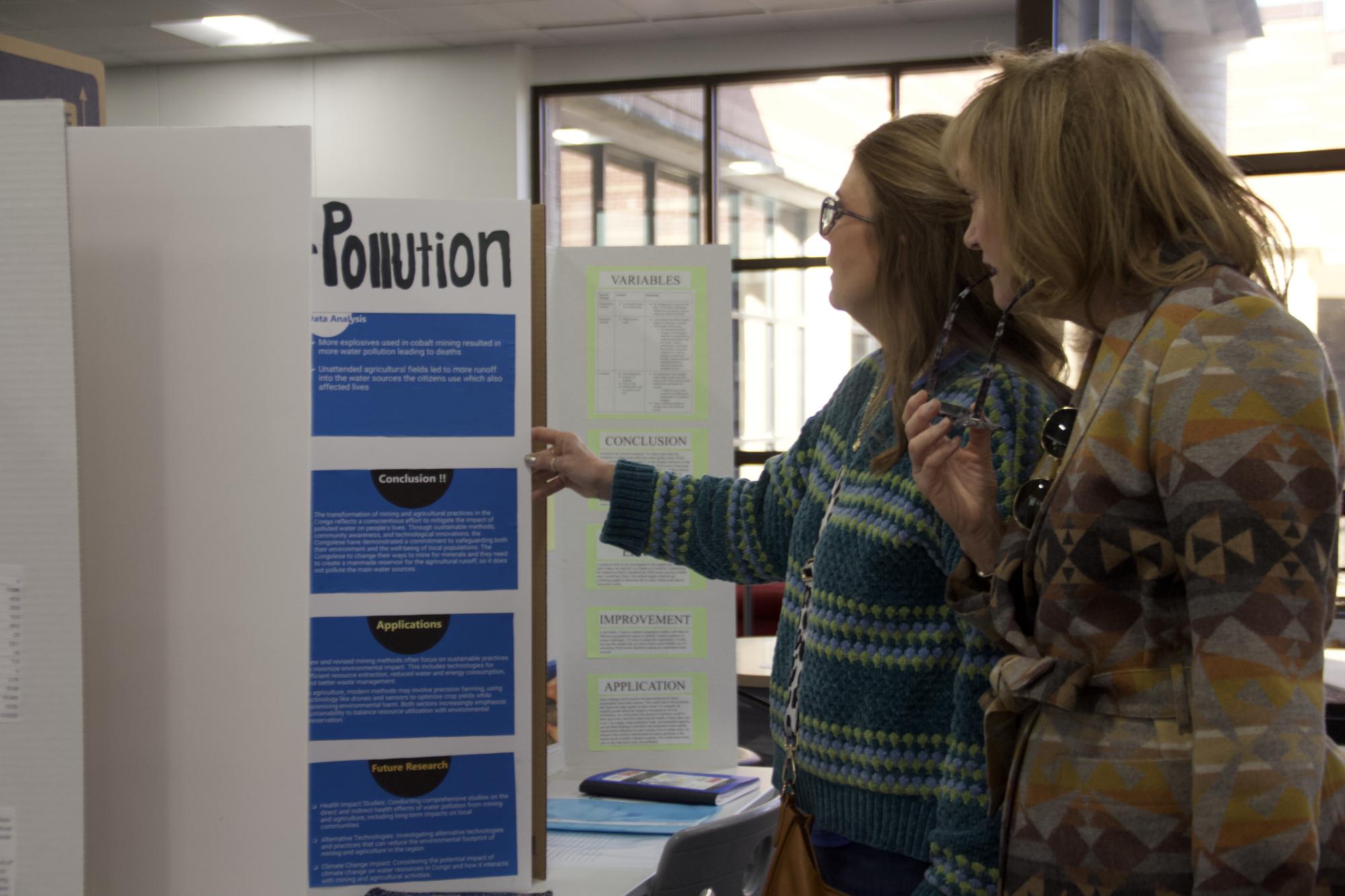 Former Coppell ISD second grade teacher Carla McCown and Former Lakeside Elementary School teacher Therese “Teri” Keith observe triboard ES6HA on water pollution. The Coppell High School Science Fair is an annual event and took place in the library on Jan. 18.
