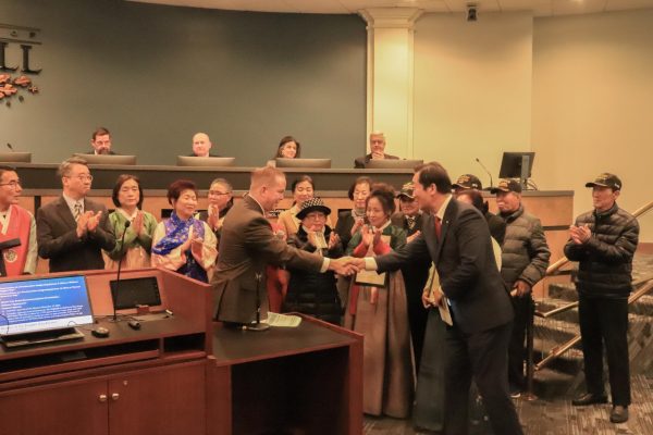 Coppell Mayor Wes Mays shakes hands with a member of the Korean Society of Dallas and Fort Worth during the official proclamation of Jan. 13 as Korean American Day in Coppell. Coppell City Council met Tuesday at Town Center.