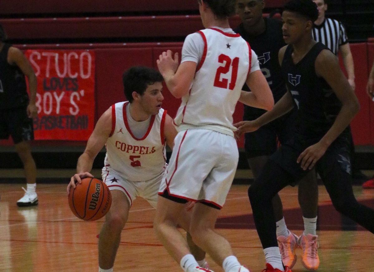 Coppell senior guard Gabe Pehl dribbles around with Hebron senior Jalen Hayes defending on Tuesday. Coppell won against Hebron at the CHS Arena, 48 - 46, on Tuesday.