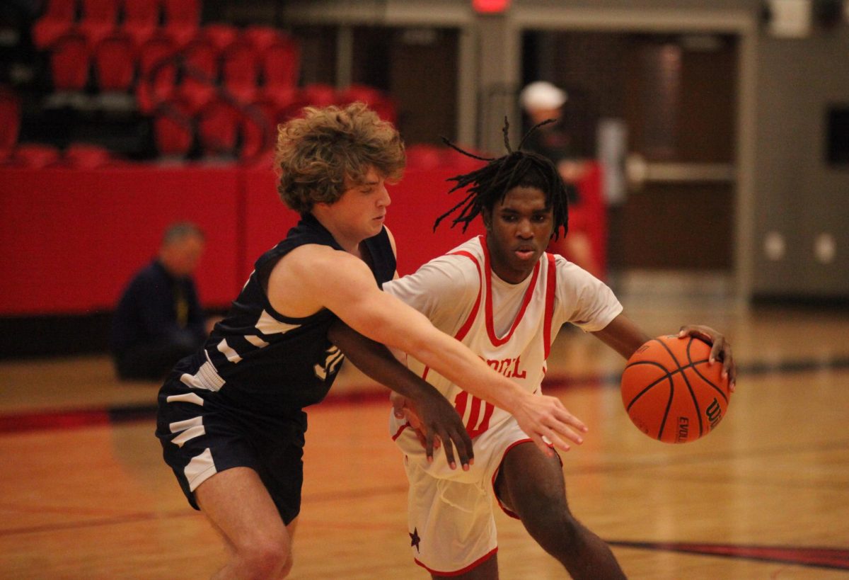 Coppell freshman guard Tre Watson drives against Flower Mound junior shooting guard Evan Leyman on Friday. Coppell plays Hebron on Tuesday at 7:30 p.m. at CHS Arena.