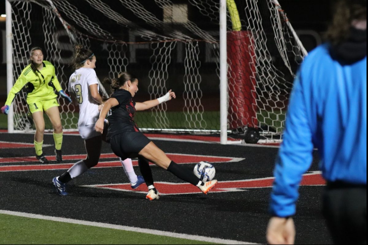 Coppell freshman forward Emeline Holder scores against Plano East goalkeeper Natalie Gillum at Buddy Echols Field. The Cowgirls defeated Plano East, 4-0. 