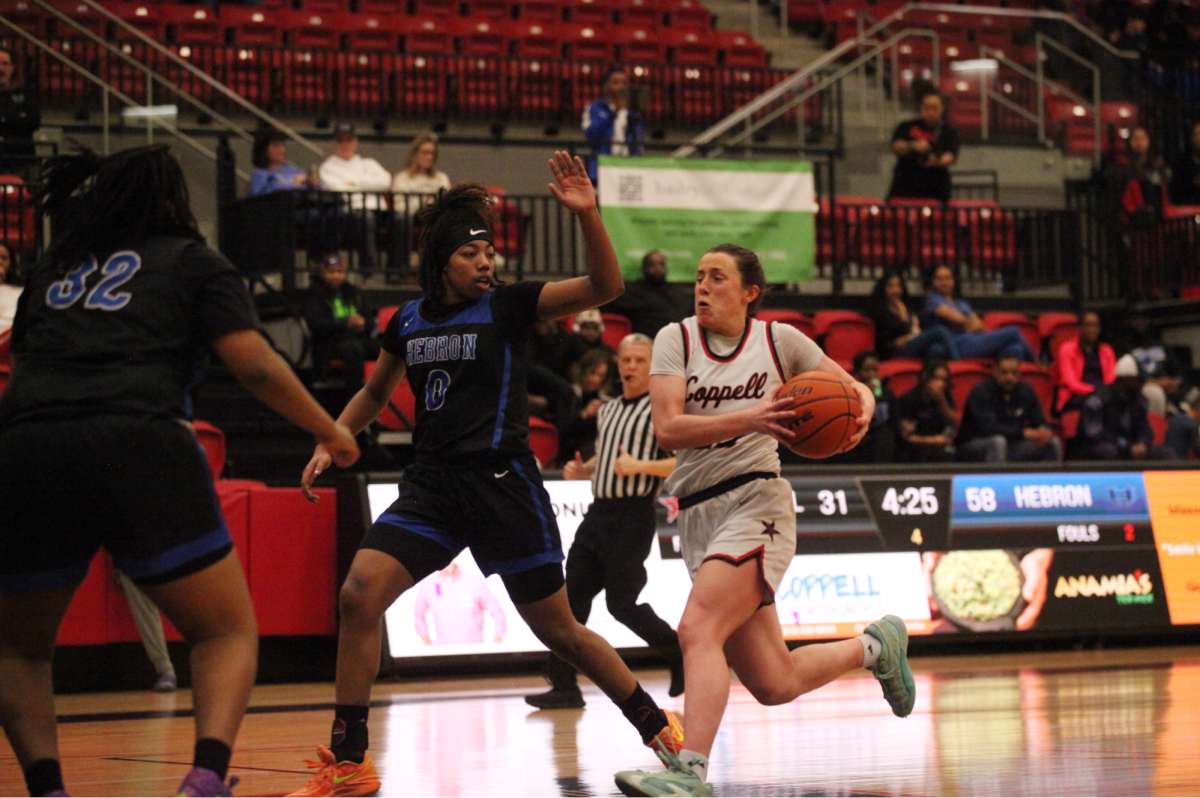 Coppell senior guard Ella Spiller drives past Hebron senior guard Micah Cooper on Tuesday at CHS Arena. The Hawks defeated the Cowgirls, 62-38. 