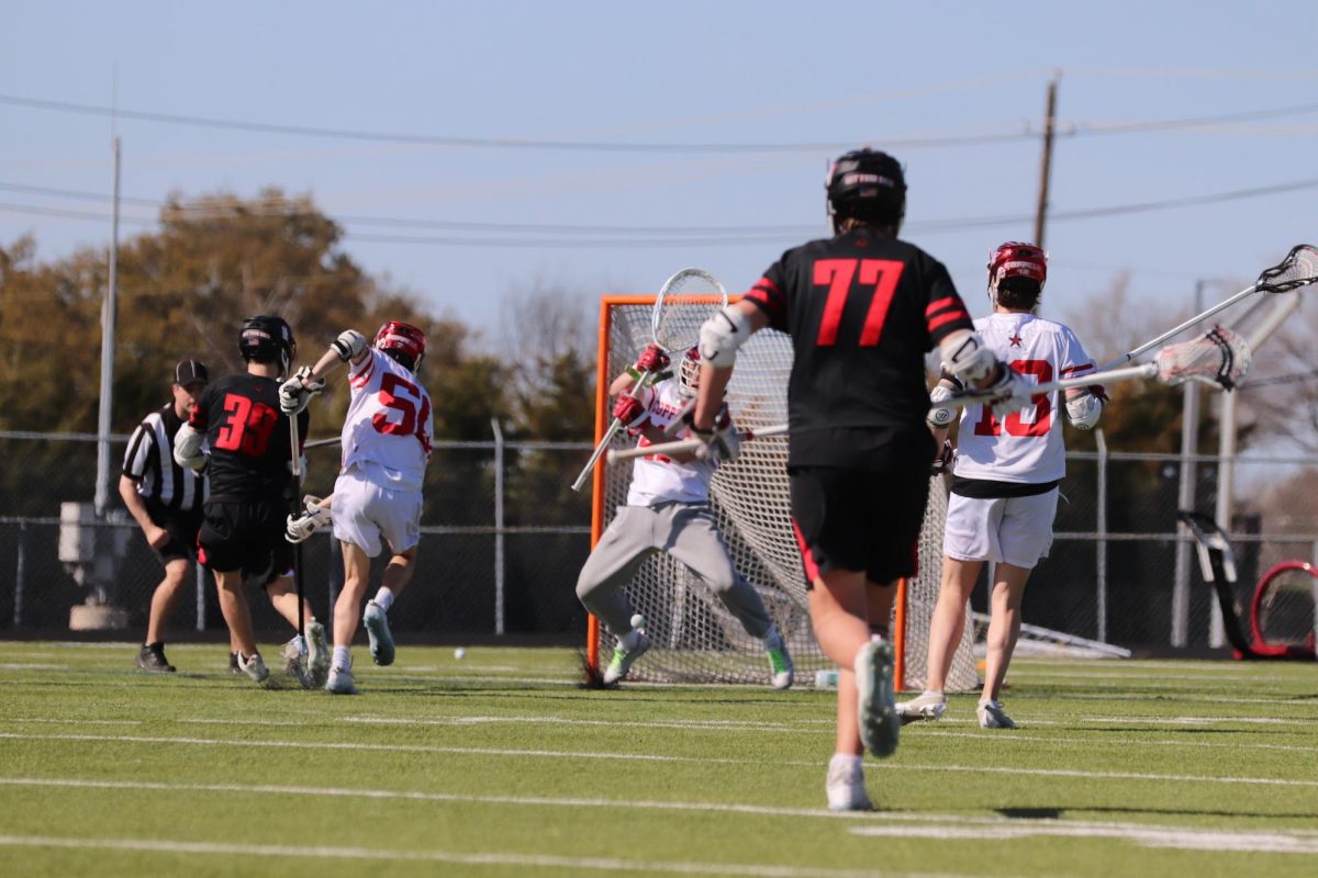 Coppell sophomore goalie Ian Nichols misses a shot by Houston St. John’s senior attack Marshall Malone. St. John’s defeated Coppell, 7-5, at Lesley Field on Saturday.