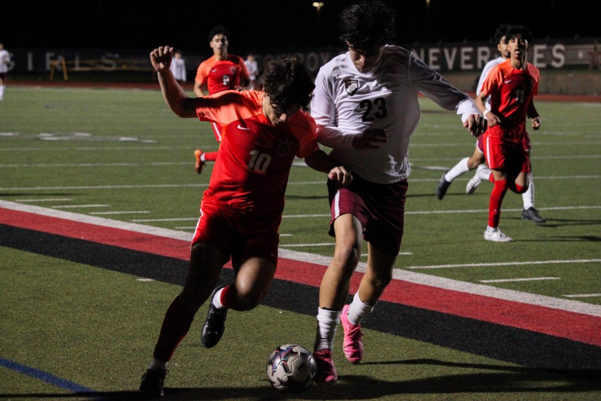Coppell senior forward Luca Grosoli and Damian Carillo of Lewisville fight for possession at Buddy Echols Field on Friday. The Cowboys defeated the Farmers, 1-0, to tie Hebron for second place in District 6-6A. 