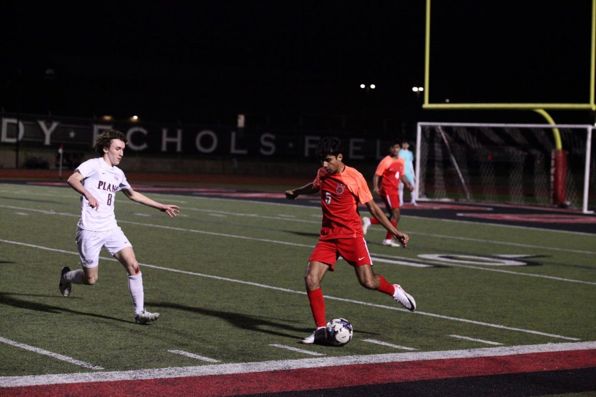 Coppell senior left-back defender Manav Kapadia rushes past Plano sophomore Cade Saylor at Buddy Echols Field on Feb. 13. Kapadia is a varsity soccer player, Coppell Red Jacket and a National Merit finalist.