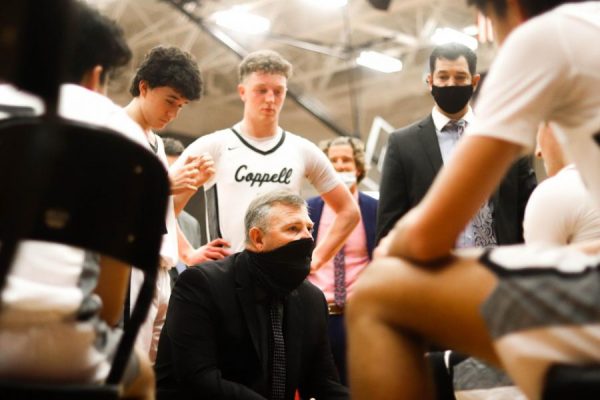 Coppell coach Clint Schnell discusses a game plan with the Cowboys prior to overtime against Lewisville on 2021 in the CHS Arena. Schnell resigned as the head coach for boys basketball yesterday after six years.