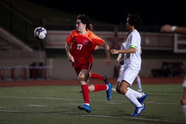 Coppell junior forward Caden Naef and Plano East senior midfielder Toby Nouanesengsy rush for possession at Buddy Echols Field on March 1. Coppell plays Prosper at 8:00 p.m. on Tuesday in the Class 6A Division Region I bi-district playoffs at Children’s Health Stadium at PISD.