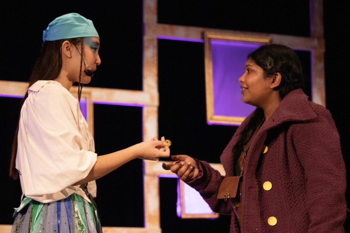 CHS9 freshmen Amy Pack and Akshita Gunasekaran as Annabel Lee and Iris exchange a coat button at the final showing of “Still Life with Iris” on March 30. The Cowboy Theatre Company performed the musical from March 28-30 in the campus auditorium.