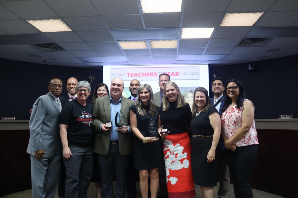 Coppell High School Sidekick adviser Chase Wofford and Austin Elementary School teacher Heather Naragon accept the awards for District Teachers of the Year, accompanied by the CISD school board and the CHS and Austin Elementary principals.
