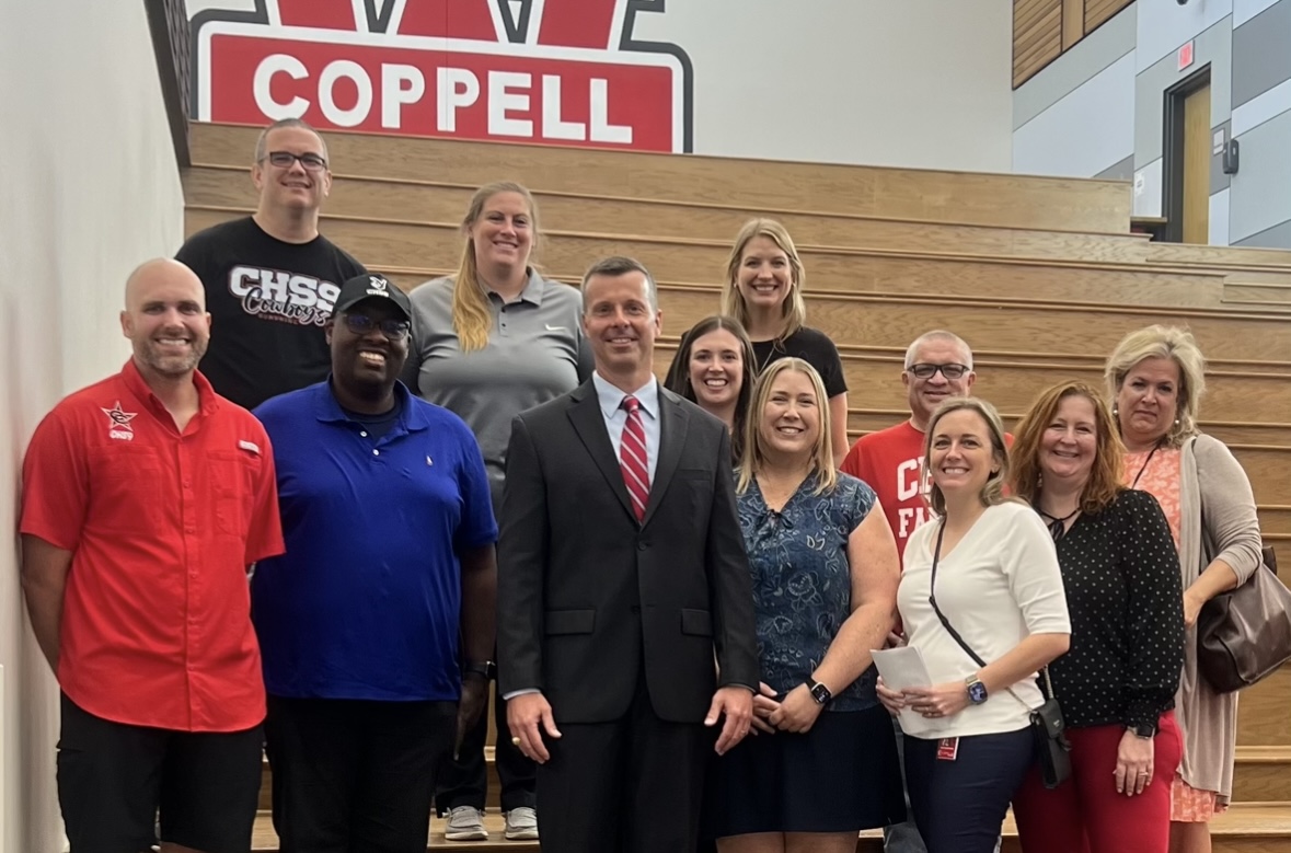 Dr. Greg Axelson (center) is celebrated as the new CHS9 principal during the Coppell ISD School Board meeting. Dr. Axelson is accompanied by CHS9 faculty at Coppell Middle School West. 