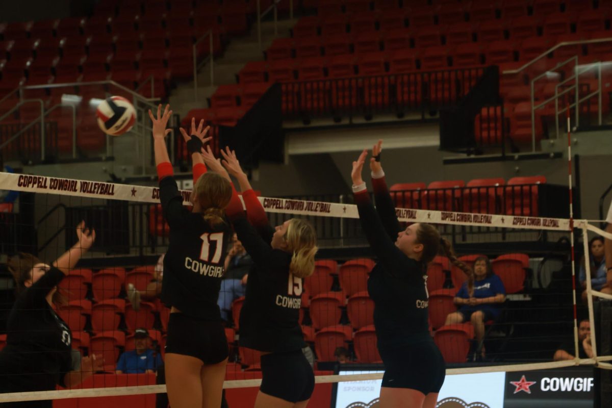 Coppell sophomore outside hitter Brooke Felix, junior defensive specialist Siena Cameron and junior middle blocker Katie Keith block against Nolan Catholic senior Trinity Foster on Friday at CHS Arena. The Cowgirls defeated the Vikings, 3-2 (25-21, 25-27, 25-17, 19-25, 16-14). Photo by Pranavi Ramineni.