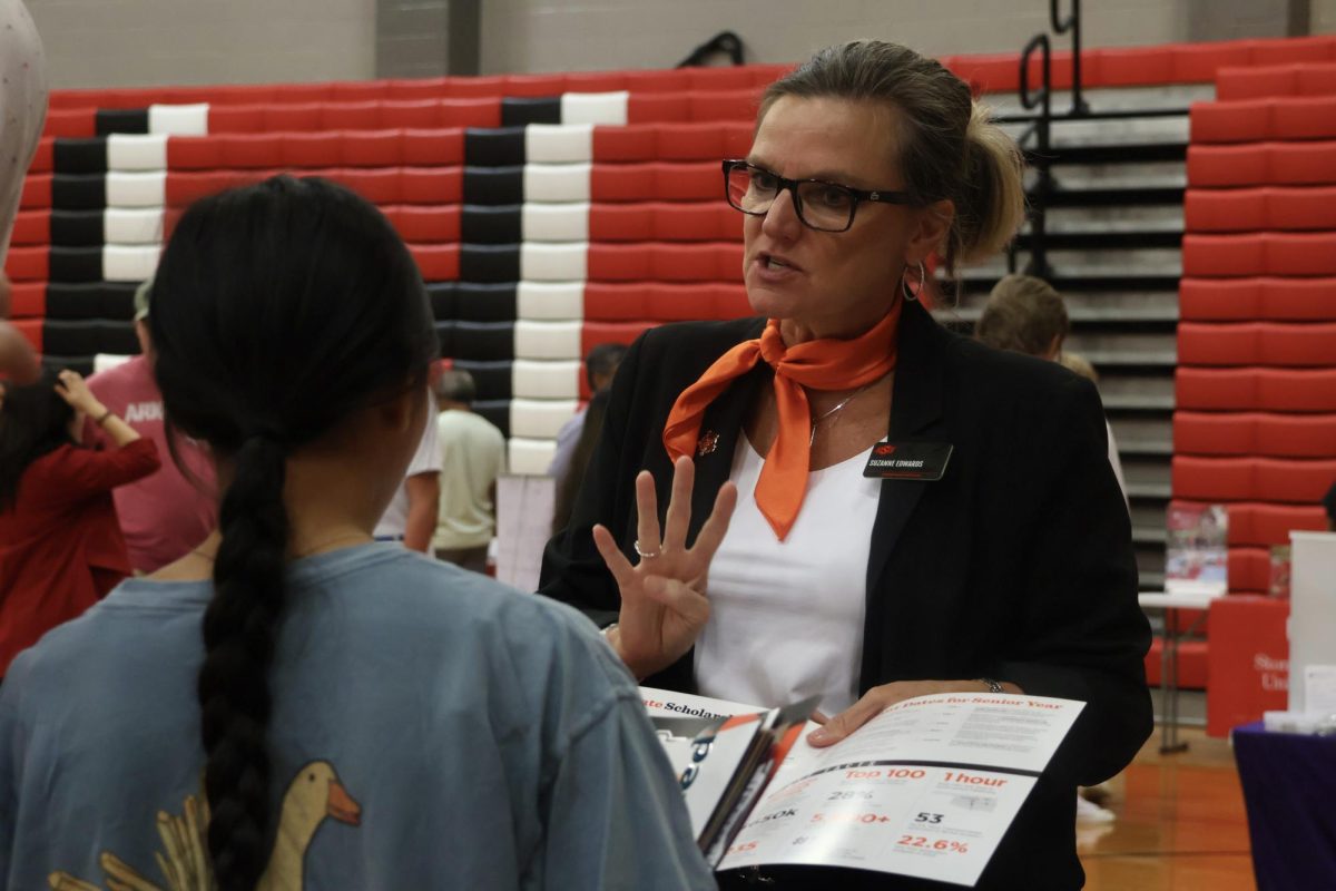 Oklahoma State University representative Suzanne Edwards explains a scholarship program to Coppell High School junior Elise McClellan during College Night on Sept. 12 in the CHS Large Gym. Numerous in-state and out-of-state universities and colleges showcased their school programs to satisfy any curiosity from the CHS community.