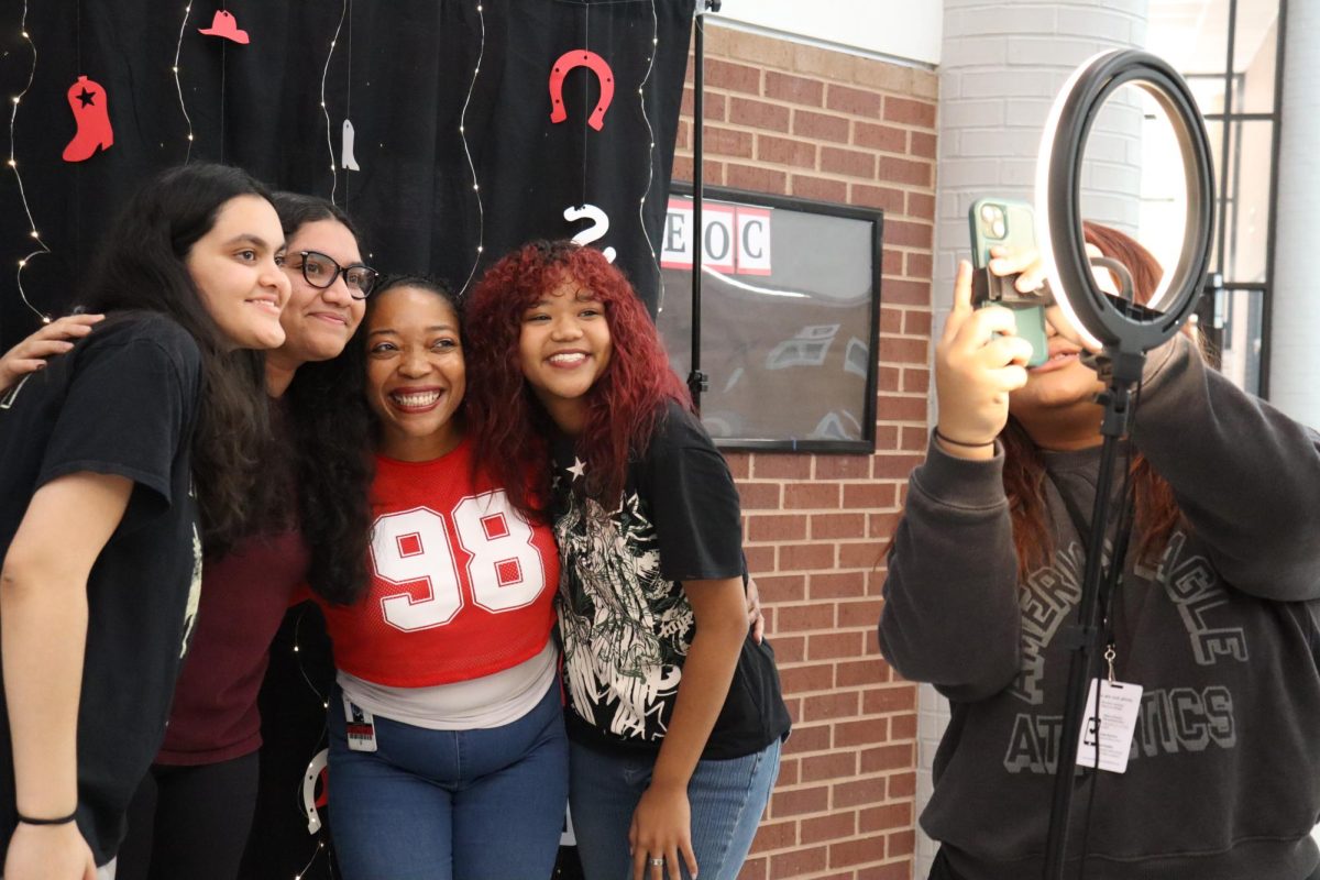 Coppell High School American Sign Language teacher Delosha Payne, junior Alexis Whitiker and seniors Arya Adhikary and Ayusha Baral take a group photo at the Large Commons during lunch on Sept. 6. Hope Squad set up a selfie booth for students and teachers to introduce their new program at CHS. 