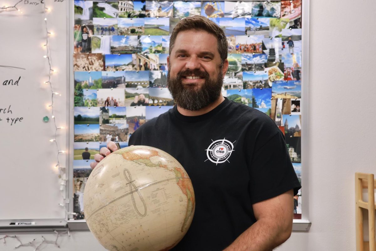 Coppell High School AP Psychology teacher Nathan Allison displays pictures of his travels across 20 countries on his bulletin board in B227. Allison, a new teacher at CHS, is the leader of the Coppell Educational Travel Program and the founder of Teachers Traveling Abroad.