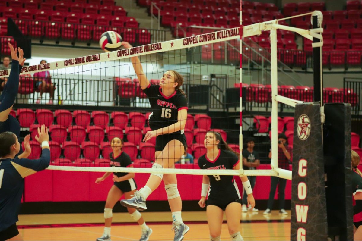 Coppell sophomore middle blocker Finley Penniman tips over the net on Sept. 20 at CHS Arena. The Cowgirls defeated the Lobos, 25-19, 20-25, 25-22, 25-17. Photo by Sohana Singh