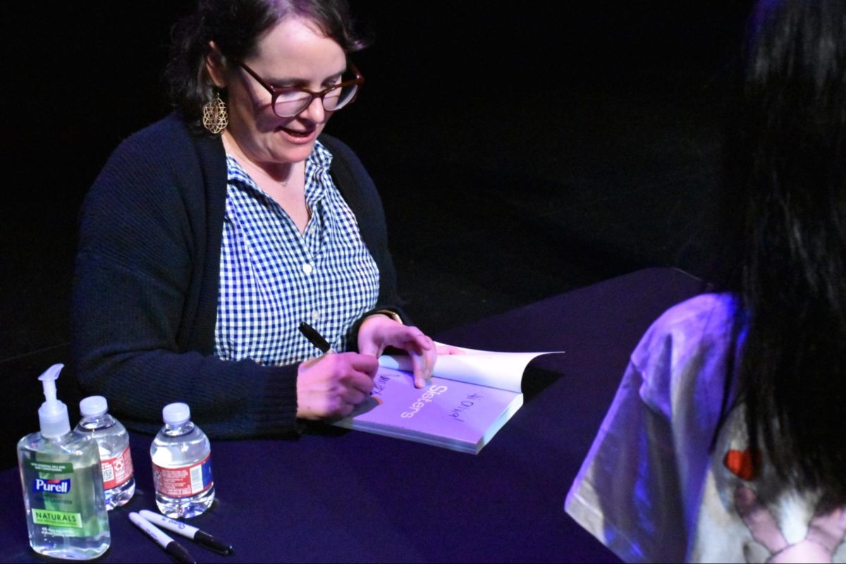 Author Raina Telgemeier autographs a fan’s copy of her second memoir “Sisters” during her book signing event. Telgemeier held an hour-long career talk and book signing event at the Coppell Arts Center on Saturday. 