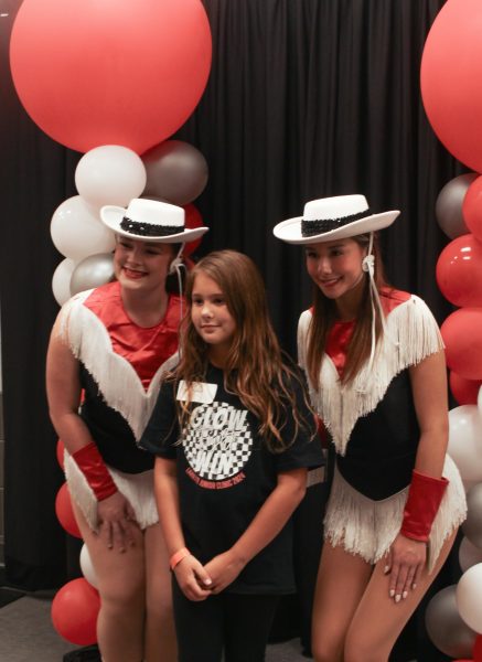 Coppell Lariette seniors Sophia Grafflin and Natalie Roels take pictures with kids during the junior clinic on Oct. 5 at CHS9. The Lariettes hosted its annual junior clinic to teach elementary students dance routines and techniques.  
