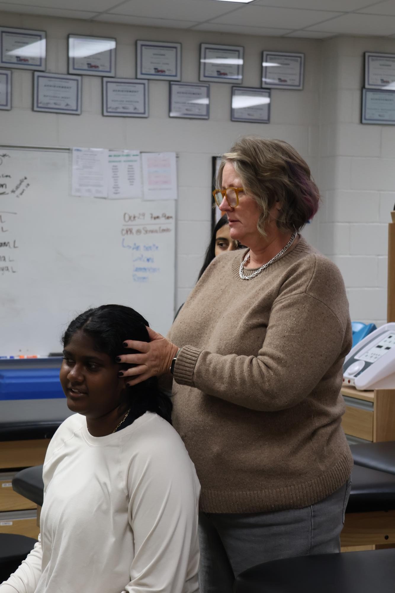 Coppell High School head athletic trainer Yvette Carson works with junior tennis player Rhea Guru during a rehabilitation session on Oct. 17 in the training room. Carson has worked with Coppell ISD athletics since 2004 as a head athletic trainer.