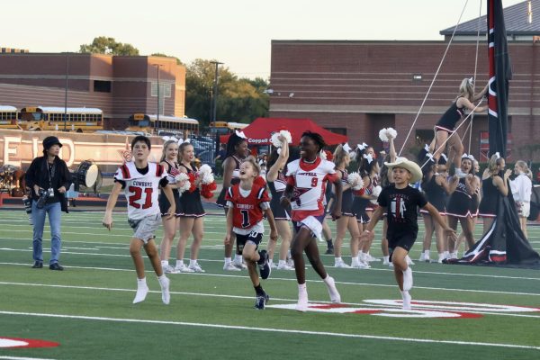 Coppell Youth Football Association breaks through banners prior to kickoff  against Hebron at Buddy Echols Field on Sept. 27. CYFA emphasizes the importance of developing football skills and fosters teamwork and sportsmanship among young players.