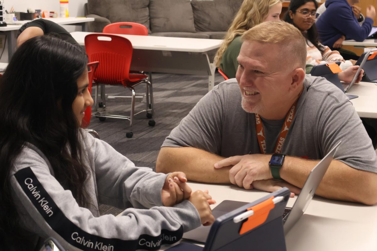 Coppell High School junior Parnika Chavala explains the purpose behind her app design to AP Computer Science Principles teacher Michael McCabe. McCabe utilizes his unique teaching style by engaging his classes to emphasize teamwork.