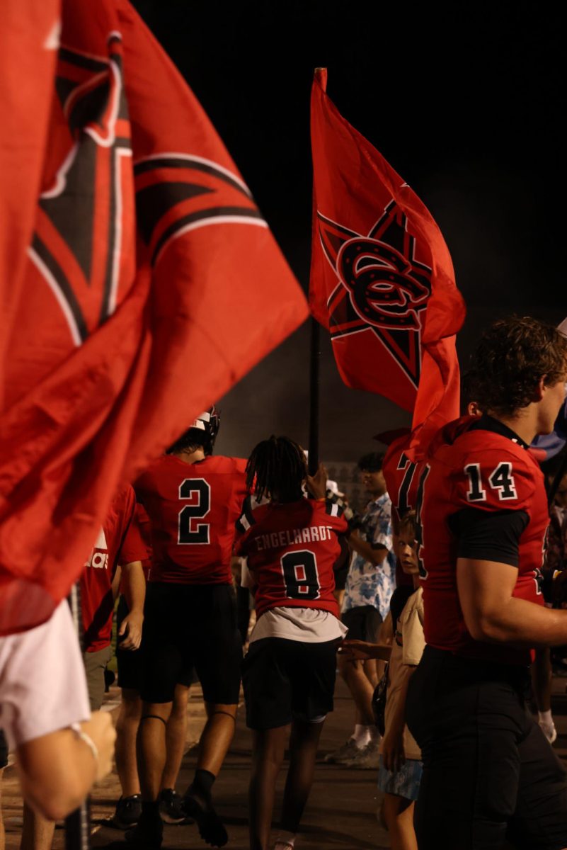 A member of the Coppell Youth Football Association carries a Coppell flag at halftime at Buddy Echols Field against Sachse on Aug. 30. CYFA emphasizes the importance of developing football skills and fosters teamwork and sportsmanship among young players.