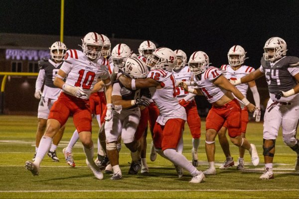 The Coppell defense tackles Lewisville senior tight end Gabriel Lewis as he fights for yardage at the 40-yard line. The Cowboys beat the Farmers, 55-28, at the Max Goldsmith stadium on Friday.