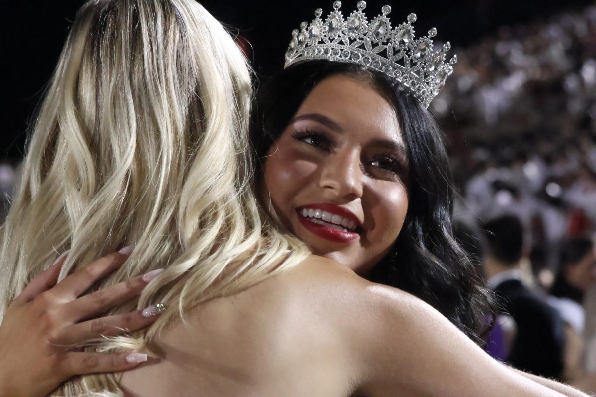 Coppell High School 2023 Homecoming Queen Tali Colclasure celebrates senior Serenity Abalos being named 2024 Homecoming Queen during halftime at Buddy Echols Field on Sept. 27. The Cowboys defeated Hebron, 49-14, in their first district game of the season.