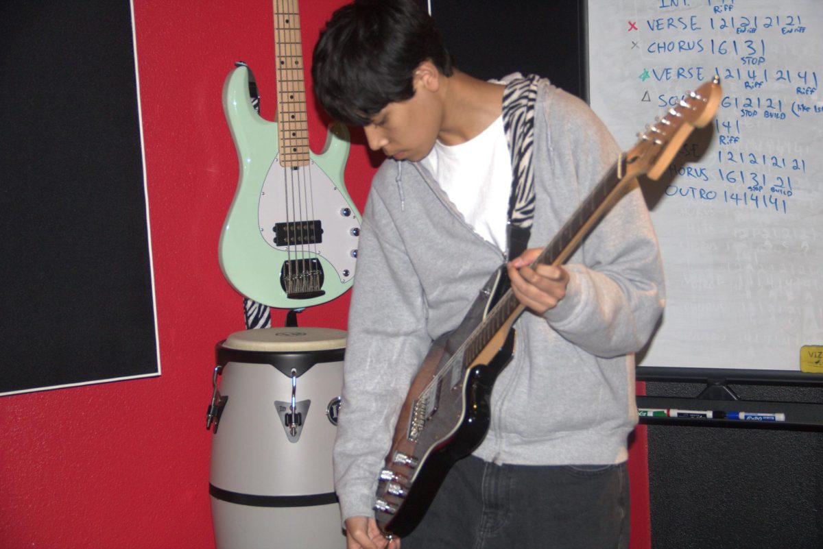 School of Rock student Josiah Rosas tunes his guitar before playing. School of Rock teaches music within a friendly atmosphere. Photo by Yoshita Sanivarpu