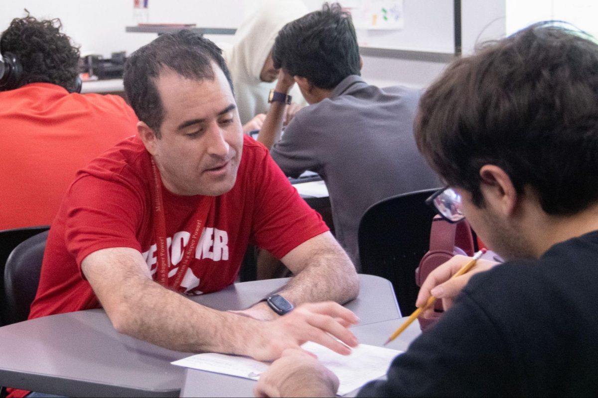 Coppell High School United States History teacher Hank Cinnamon helps sophomore Angel Gonzales review test questions. Cinnamon fosters a safe and engaging environment in the classroom.