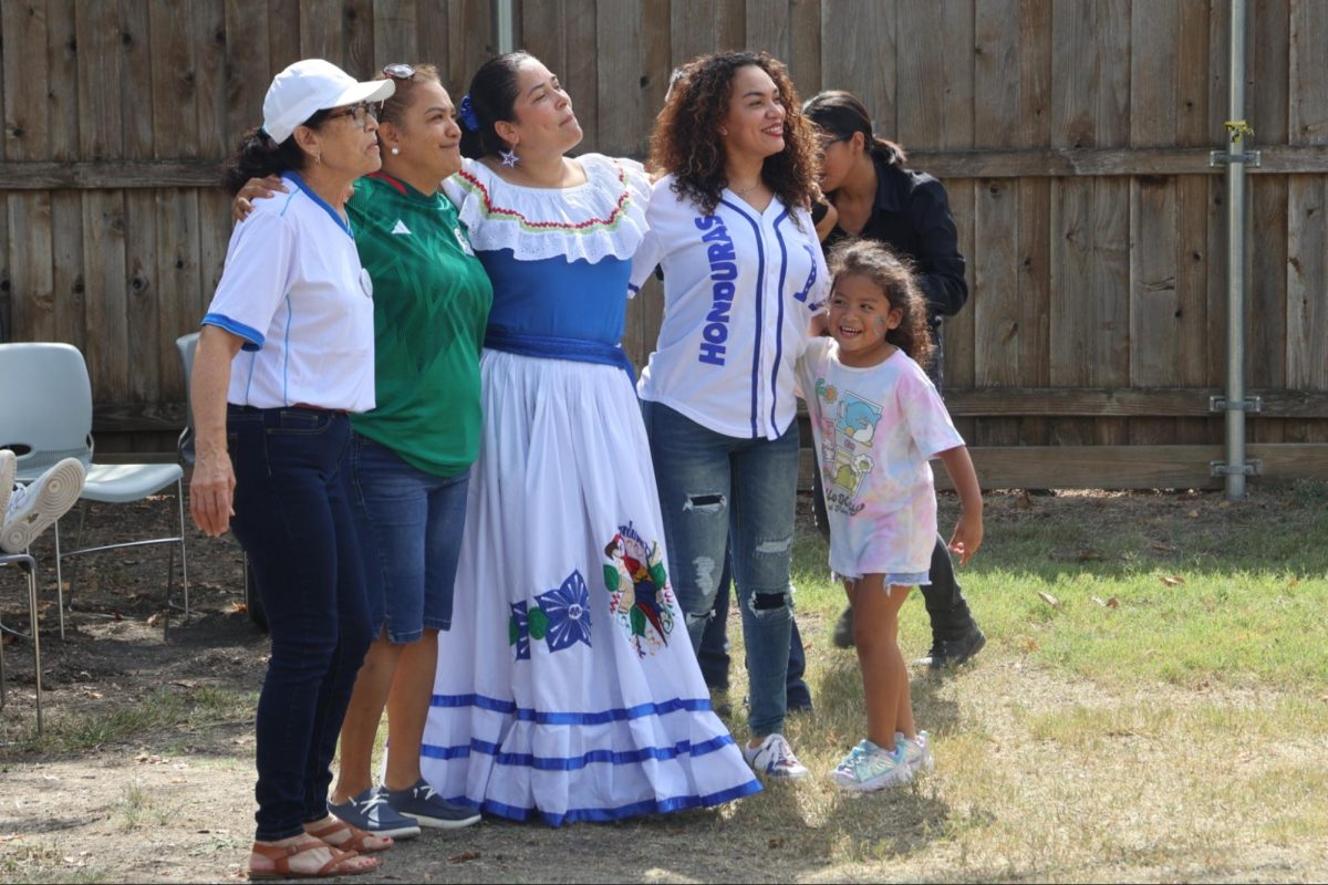 Sissy Davila (middle) and her family dance to live music during the Latino Hispanic Festival on Oct. 5 at Coppell Historical Museum. Davila operated a booth at the festival providing information and items representing Honduras. The Latino Hispanic Festival featured displays and performances from South American countries, bringing together families and friends across the community.